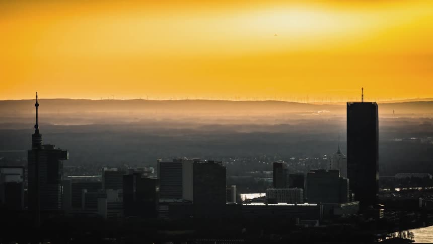 The sun rises in the sky over the large city