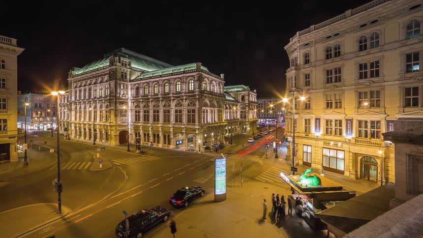 Timelapse shot from a rooftop of a city street intersection at night