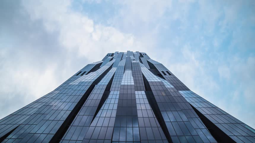 Looking up towards a high rise with many windows from below