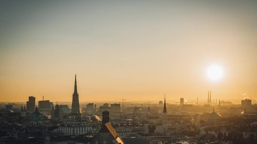 The sun looms over a large cityscape