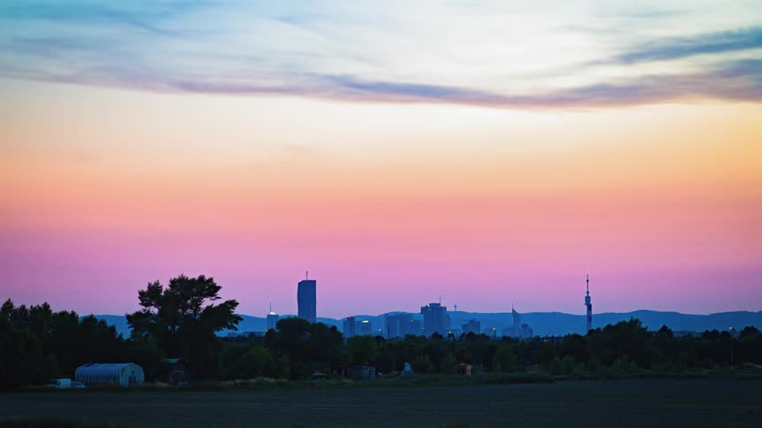 A city sits in the distance while a farm and farmland sits in the foreground