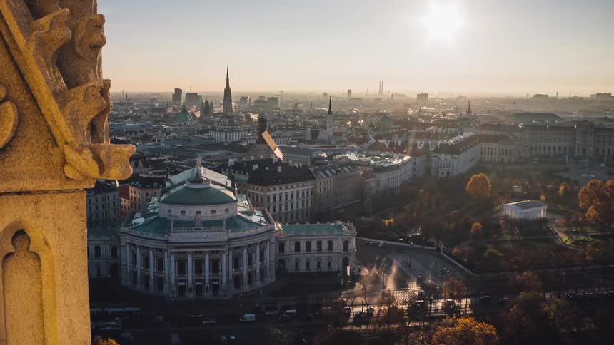 The sun rising over a city full of architecture and traffic