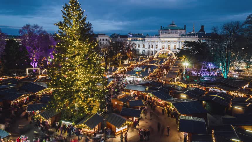 People shop at a large market in a square