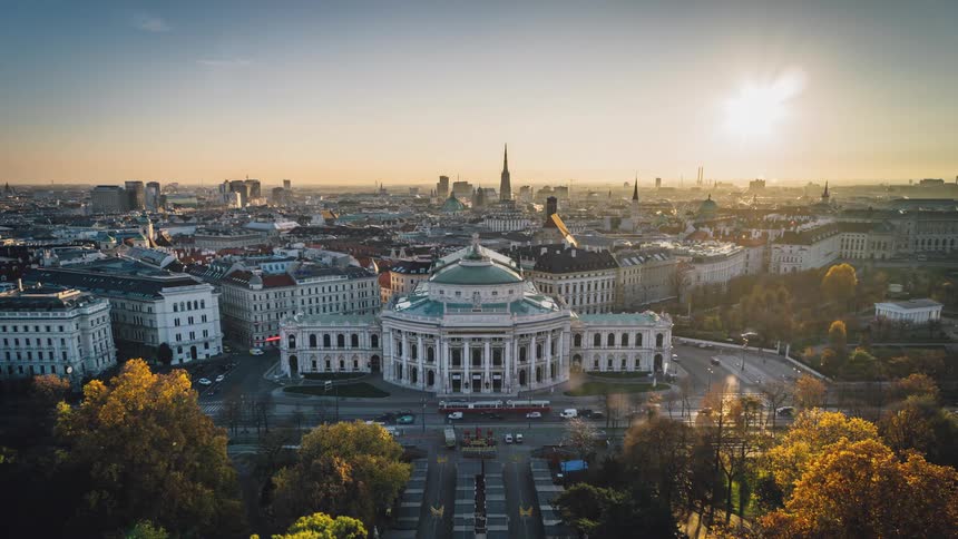 The sun rises behind capitol buildings as vehicles pass by throughout the day