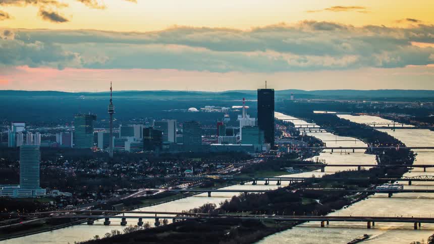 Cars travel on busy city streets and bridges at dawn