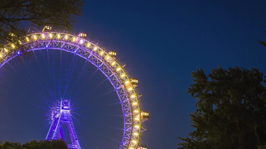 A ferris wheel spins around as day becomes night