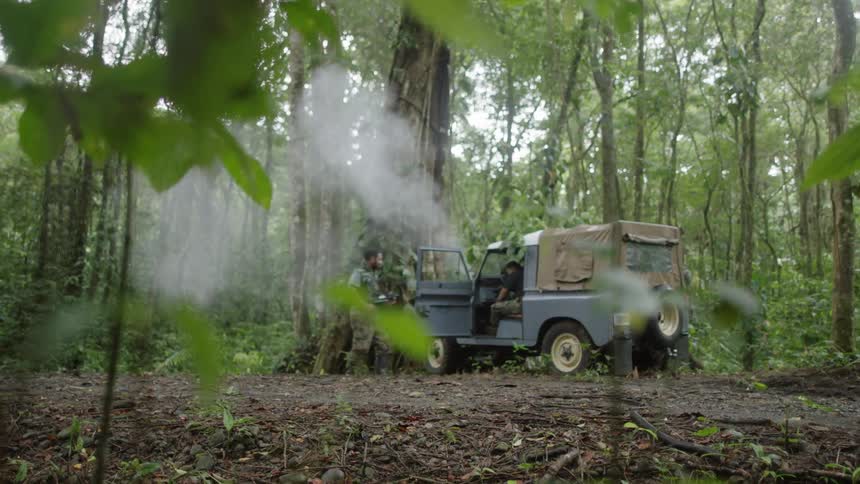 Two soldiers run to a vehicle and discover an injured person inside