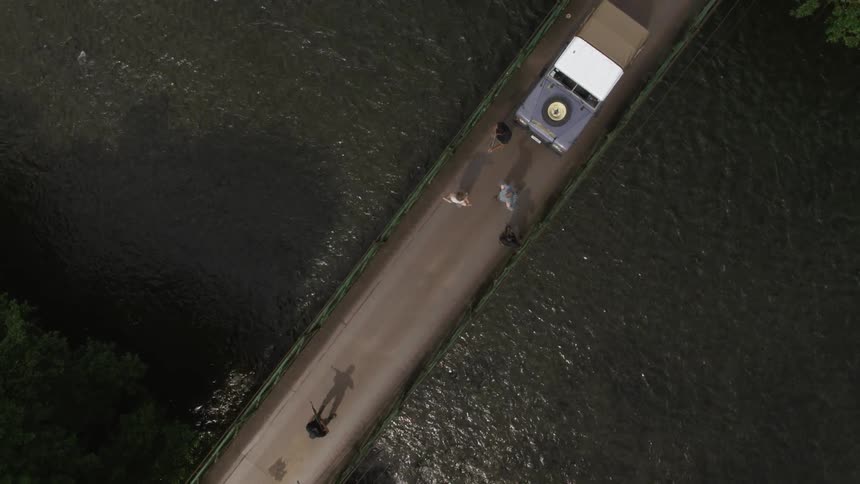 A couple crossing a bridge being detained by armed forces