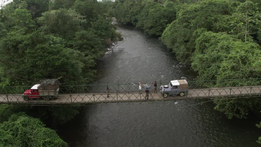 People are led into a van at gunpoint on a suspension bridge