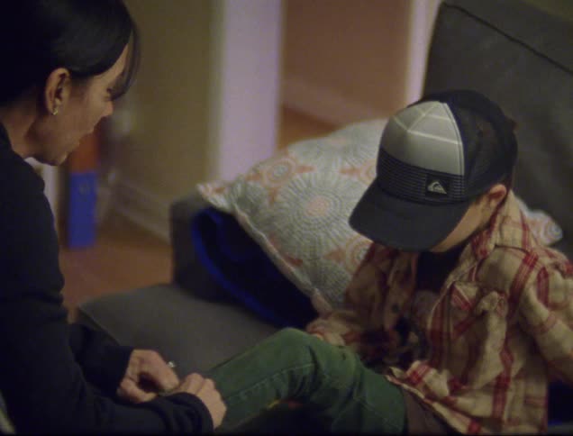 A little boy who bruised his knee is comforted by a little girl and a young woman