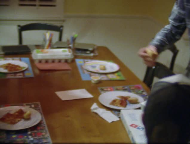 Man serves cookies onto plates while boy walks in the room