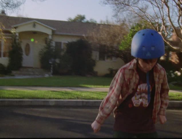 Kid skateboard down suburban neighborhood street
