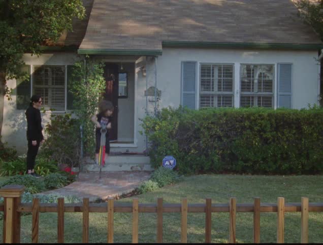 Girl jumping on pogo stick outside house