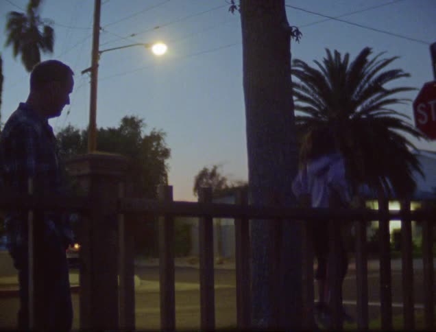 Ayounggirl jumps on the trampoline while an adult malewatches her