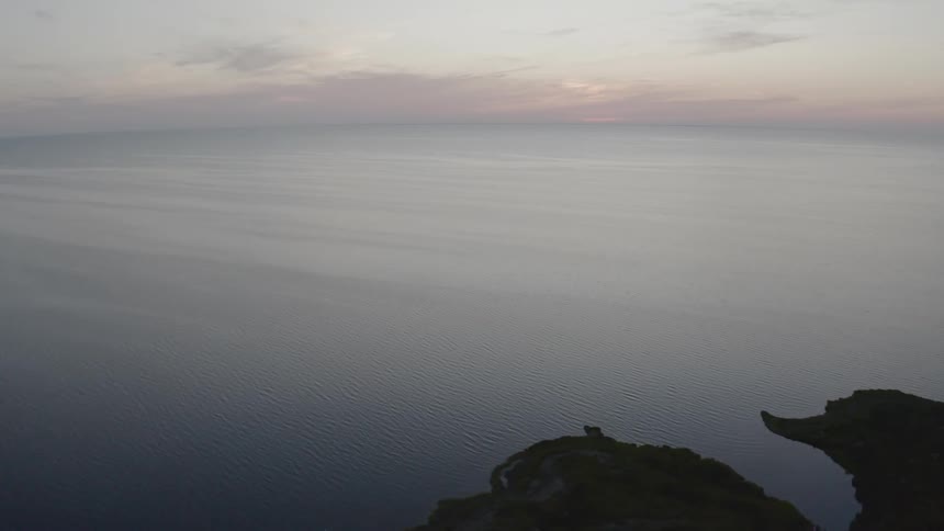 An aerial view of a shoreline and ocean at sunrise
