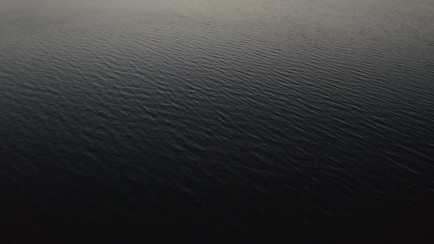 Camera flies over a large body of water