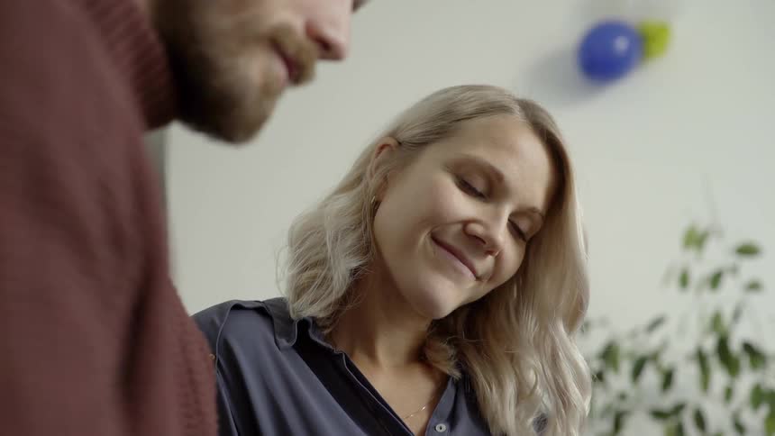 A man and woman sit and talk and laugh together