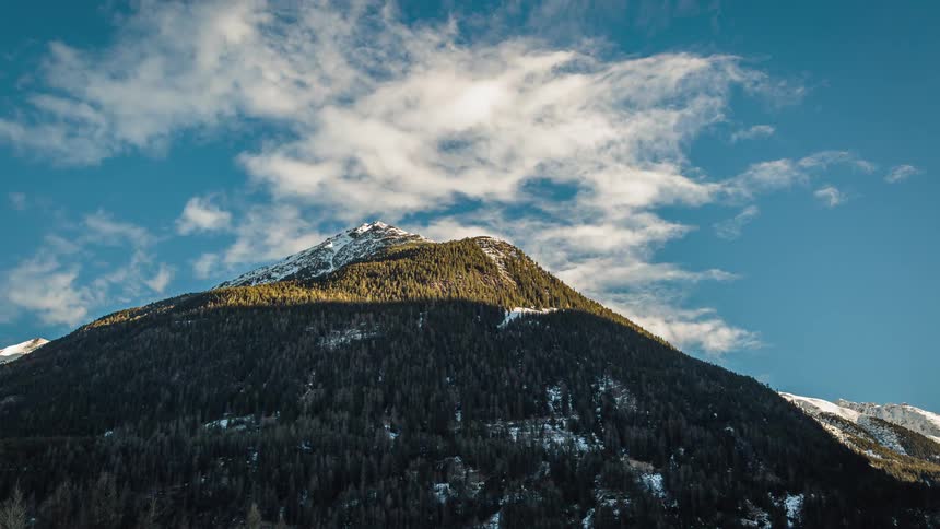 Clouds pass over a hill top