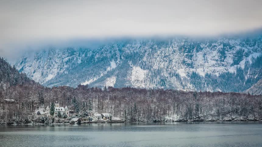 Town bordered by ocean and forest with mountain on the horzon