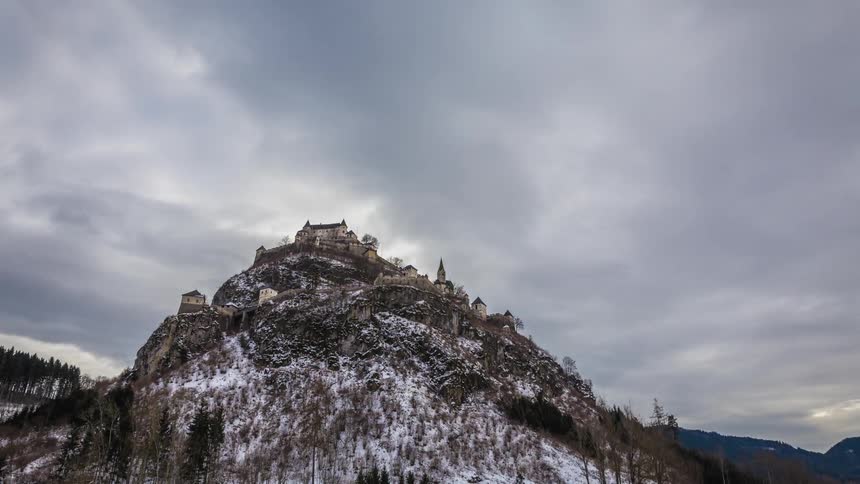 A time lapse of a castle on a hill with clouds passing by