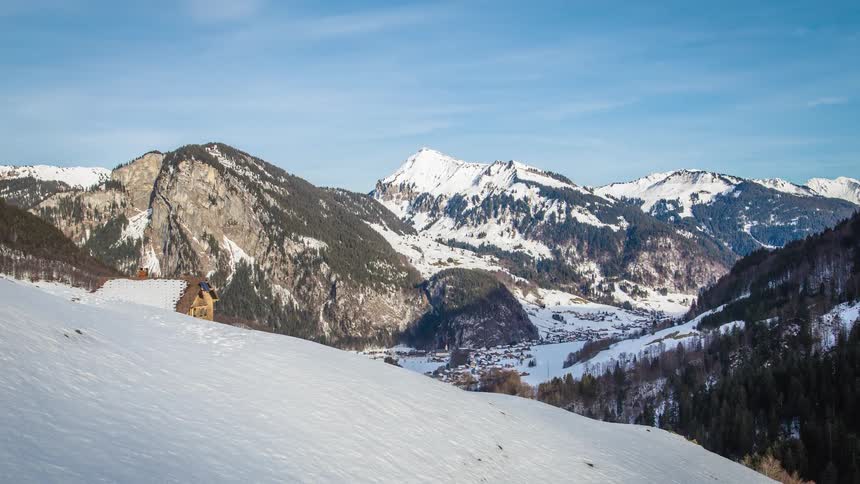 A house on the edge of a mountain in the snow covered winter