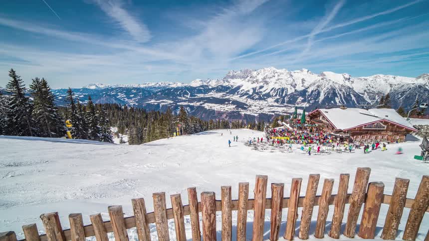 Crowds of people ski around a skiing lodge