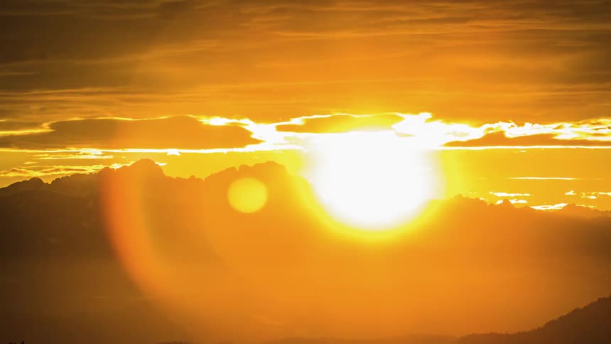 Sun sets behind mountain range