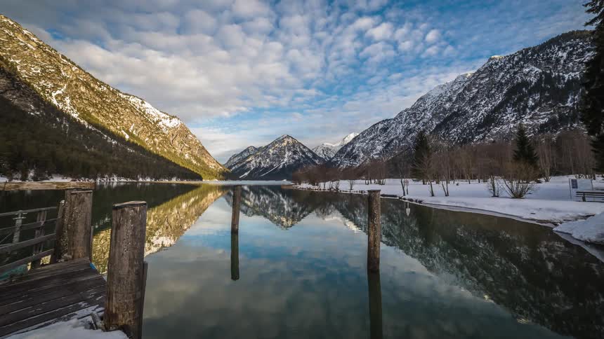 Clouds move over a lake in a mountain valley