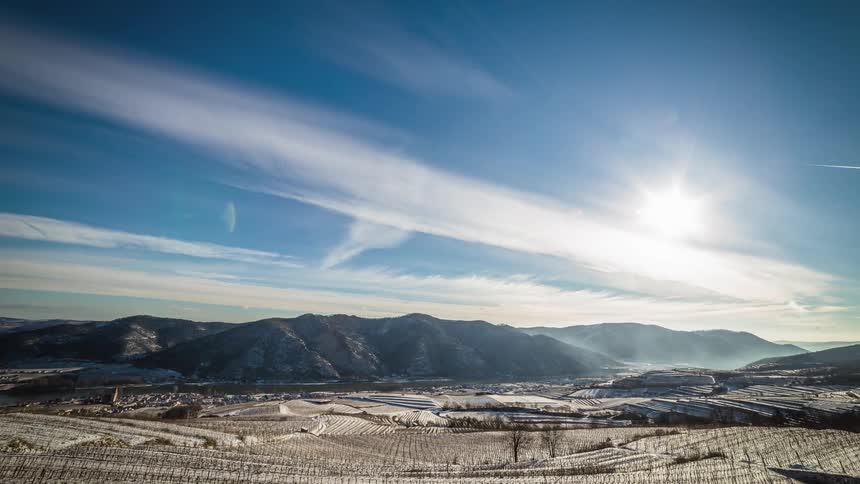 Clouds race across a valley covered in farmland