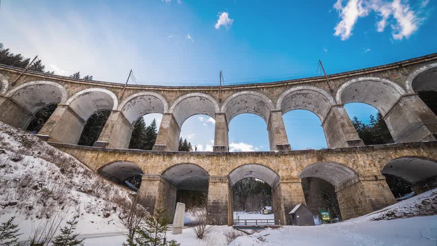 Several people walk along an ancient roman aqueduct