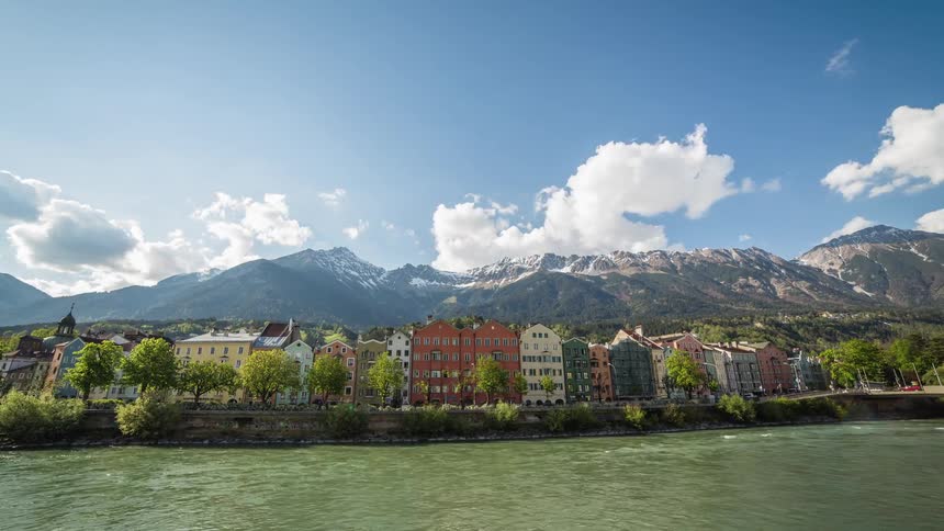 A river flows past a coastal road and a city with tall buildings
