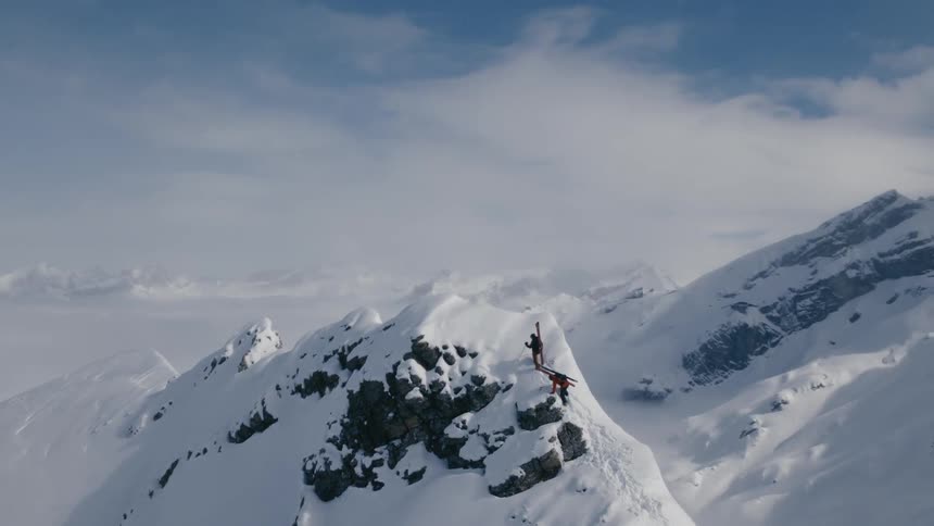 A pair of mountain climber ascending the peak of a mountain ridge