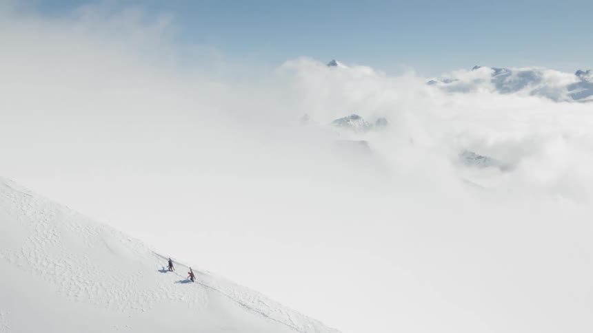 The skiers trek up a snow covered mountain