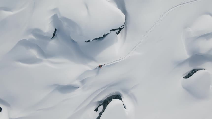 Cross country skier travels across snow covered terrain