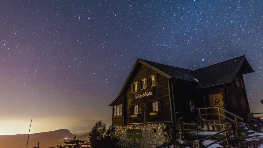 Time lapse of night sky over cabin