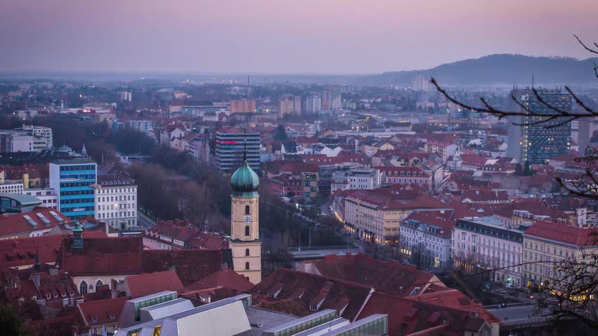 Night falls over red roofed low rise buildings near mountain