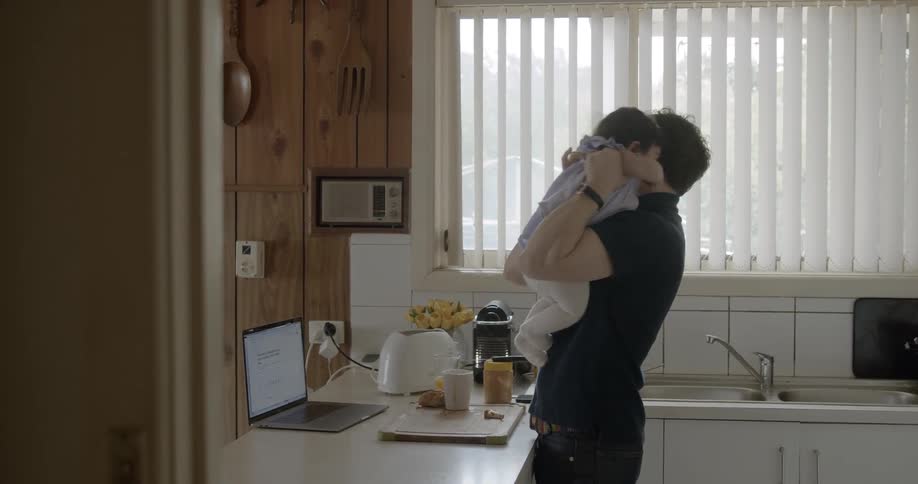 Man plays with his little daughter in a kitchen