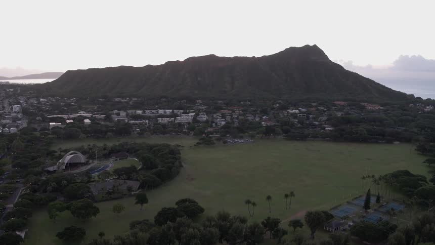 An aerial view of a golf course with a mountain backdrop