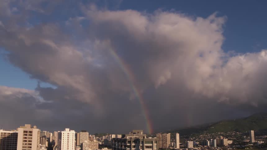 Landscape view of a city with clouds and a rainbow