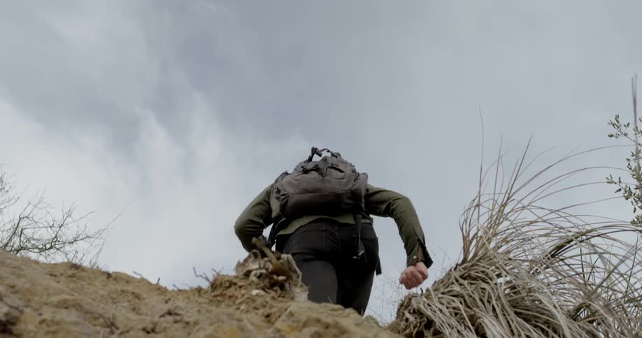 A man hikes up a mound of dirt
