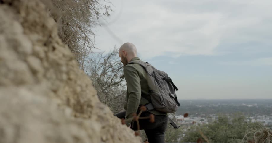 A man is hiking up a cliff