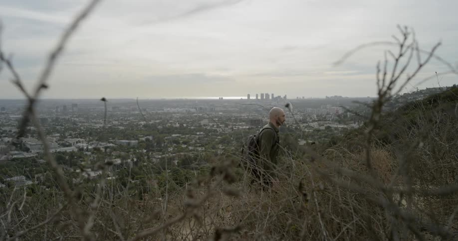 A man wearing a back pike hikes up a mountain