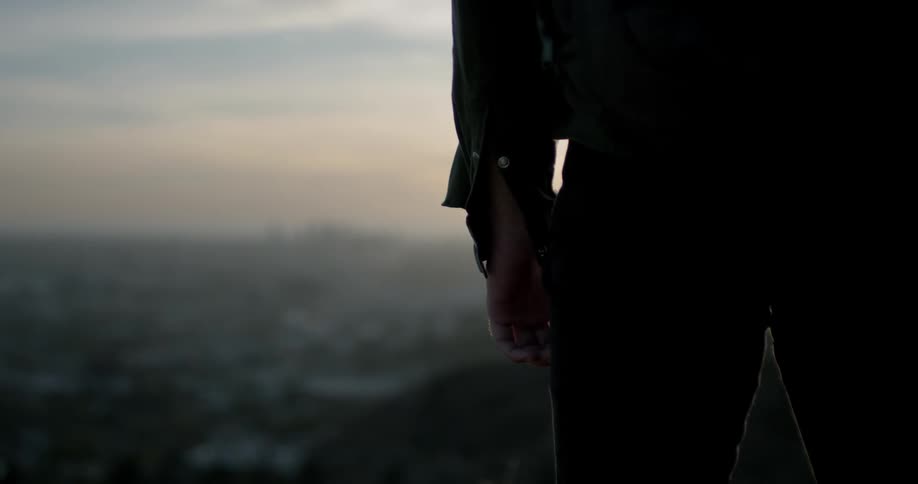 A person standing on a hill looking out over the valley below