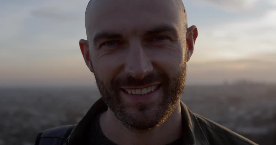 A white man turns his face up and smiles broadly