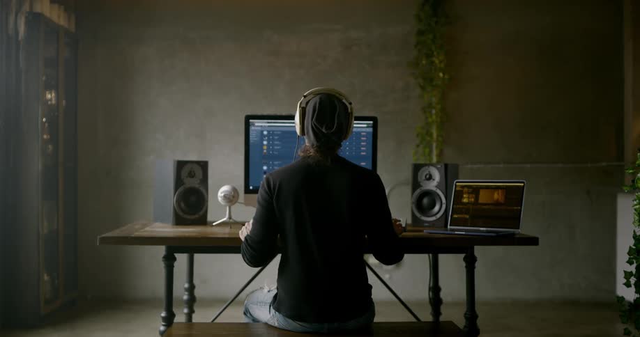 A man listens to music and works on his computer