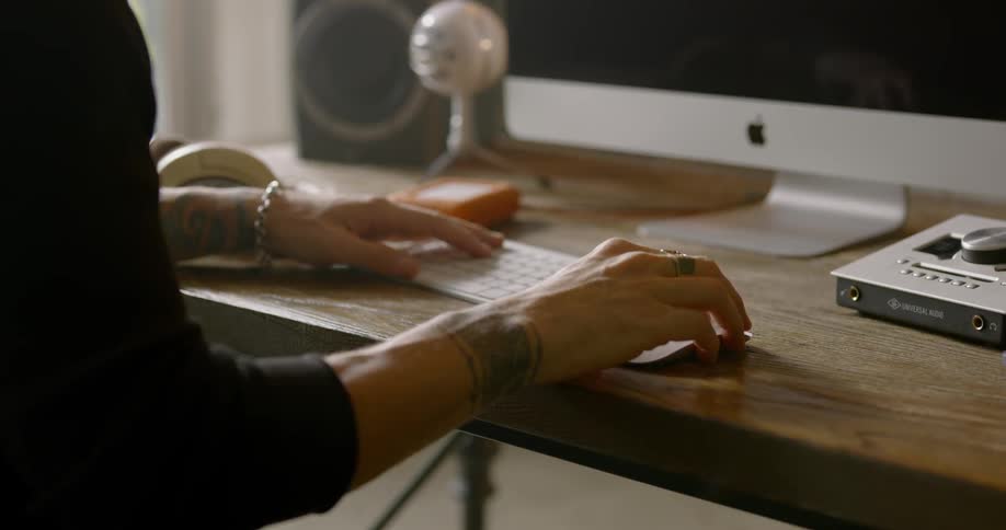 Woman types on a keyboard as she sits at a desk