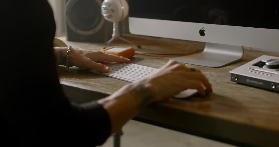 A person types on a keyboard while sitting at a desk