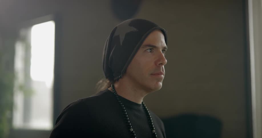 A man in a beanie looking at a canvas