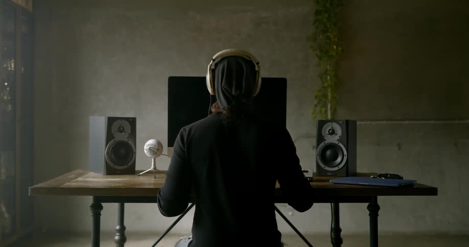 Person sits behind the monitor and puts on headphones