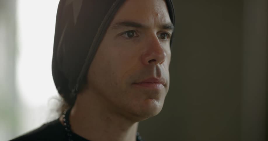 A man in a beanie looking at a screen